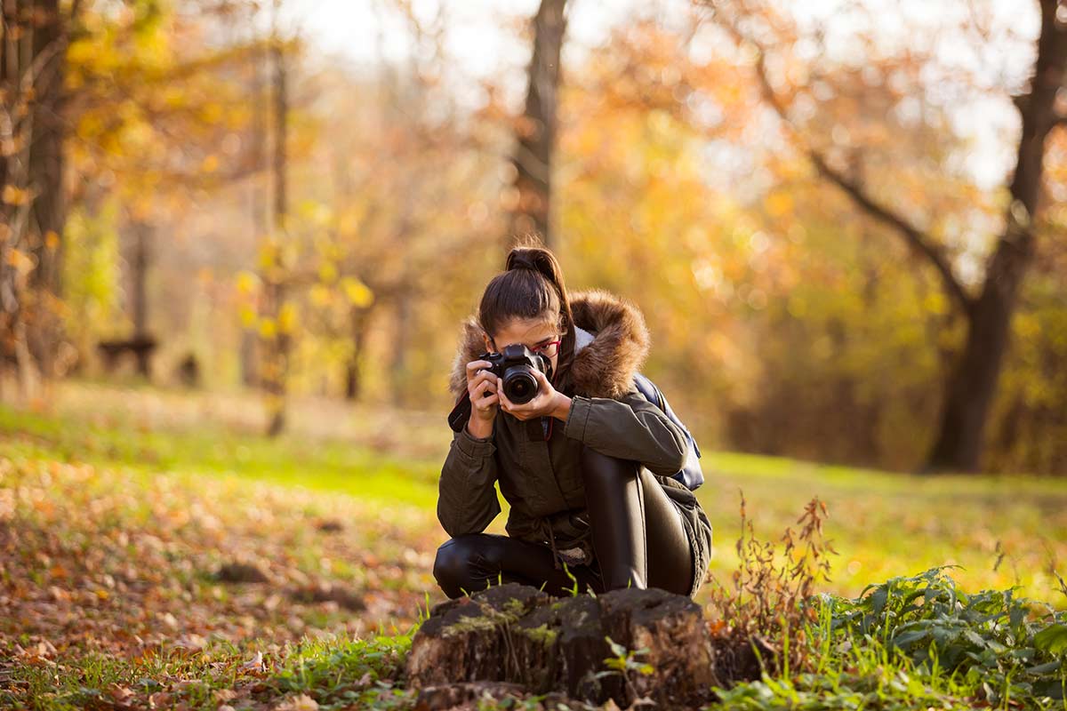 Mujer tomando fotos en el bosque 